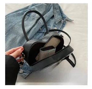 Detail view of heart-shaped bag interior showing capacity for wallet and card holder