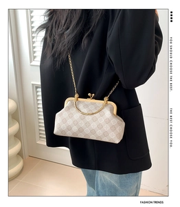 Dettaglio della borsa vintage beige con manico in metallo dorato e tracolla a catena