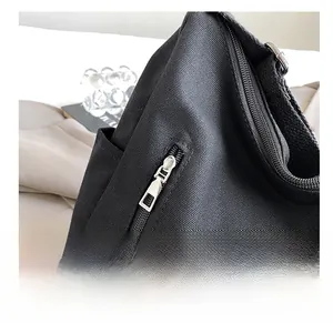 Vue détaillée de la fermeture éclair en métal argenté d'un sac cabas en toile noire