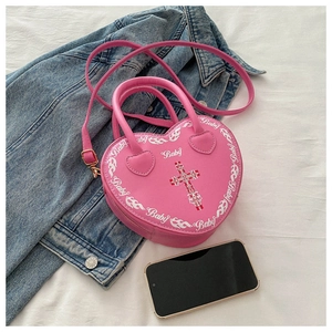 Detail of pink heart-shaped PU leather bag with Baby text and cross pattern