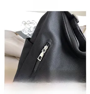 Gros plan de la fermeture éclair en métal argenté sur un sac fourre-tout en toile noire