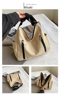 Détails du sac fourre-tout en toile kaki avec sangles noires et poches zippées devant