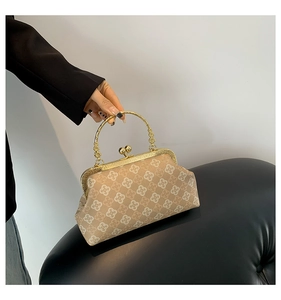 Dettaglio borsa beige vintage a fiori con manico tondo dorato e chiusura a scatto