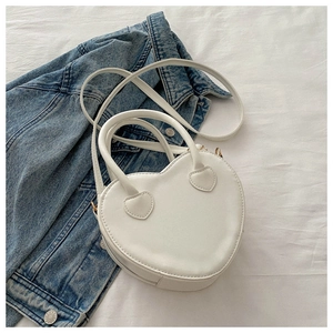 Detailed macro view of heart-shaped white PU leather bag with gold hardware and zipper