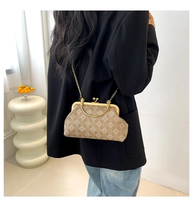 Dettaglio borsa vintage marrone chiaro con motivo floreale e catena in metallo dorato