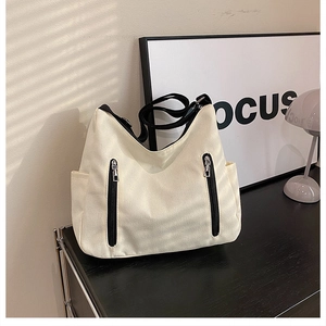 Détail du sac fourre-tout en toile beige avec lanières noires et fermetures éclair