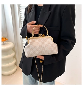Dettaglio borsa beige con motivo a rombi e manico con cornice in metallo dorato