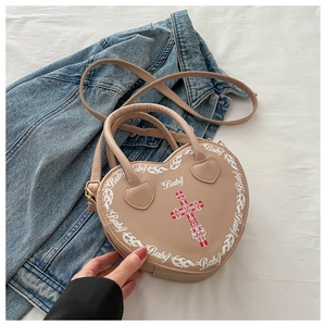 Detail of beige heart-shaped PU leather handbag with gothic cross print and top handle