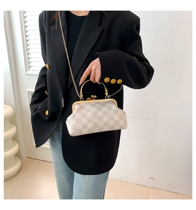 Dettaglio borsa retrò beige con chiusura a scatto e catena in metallo dorato