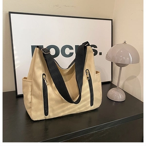Vue détaillée du grand sac fourre-tout en toile avec poches zippées et bandoulière large