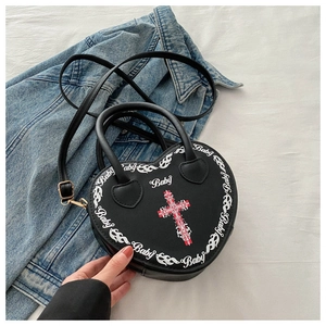 Close-up of heart-shaped black handbag with baby text print and cross detail