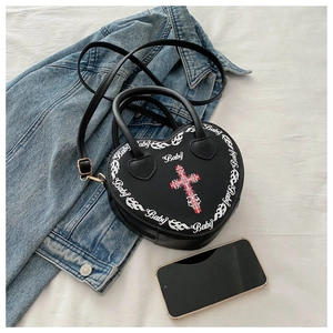 Detail of heart-shaped PU leather bag with Baby text and cross graphic on fabric
