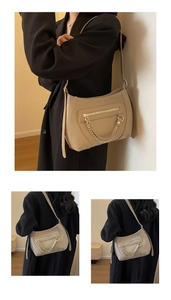 Detail of khaki leather tote bag with gold chain strap and front zipper pocket