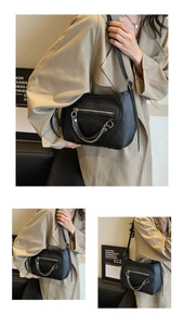 Detail of black pebbled leather texture and silver chain on minimalist shoulder bag