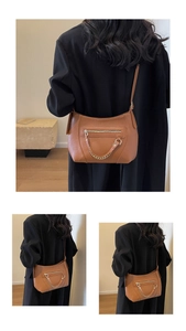 Close-up of brown litchi grain leather tote bag with gold chain and front zipper pocket