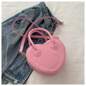 Pink heart-shaped faux leather handbag with top handles and adjustable crossbody strap