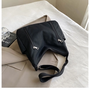 Détail du sac fourre-tout noir avec poches zippées et bandoulière large réglable en toile
