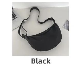Detail view of the black crescent crossbody bag showing nylon texture and zipper
