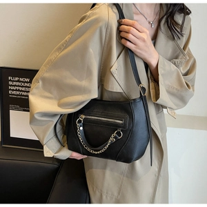 Detail shot of black litchi texture tote bag with golden metal chain and zipper pocket