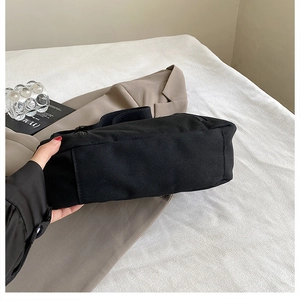 Gros plan détaillé sur la structure plate du fond et les coutures de ce sac cabas en toile noire
