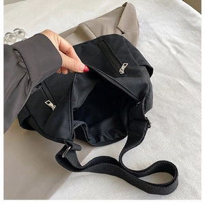 Vue détaillée du sac fourre-tout noir en toile avec fermetures éclair argentées