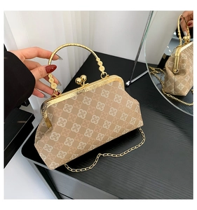 Dettaglio borsa a tracolla in pelle stampata beige con manico dorato e chiusura in metallo