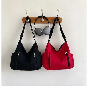 Détail du sac fourre-tout en toile avec poches zippées et compartiments latéraux