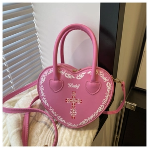 Detail of pink heart-shaped leather bag with Gothic cross and Baby lettering print
