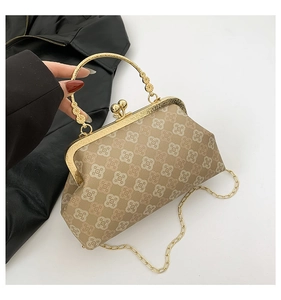 Dettaglio della borsa vintage con chiusura a conchiglia dorata e motivo geometrico floreale