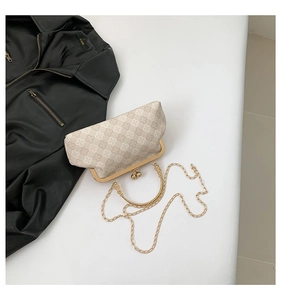 Dettaglio borsa vintage con stampa floreale, chiusura a conchiglia e catena dorata