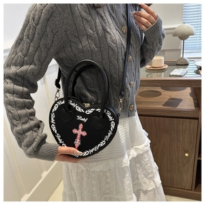 Detail of a black heart-shaped handbag with white flame print and Baby text