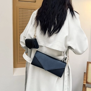 Chic black crossbody chain bag set with gold hardware on beige trench coat outfit