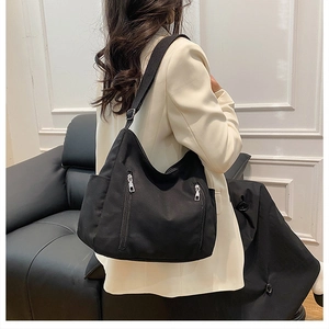 Détail du sac bandoulière noir avec deux poches zippées verticales et large sangle réglable