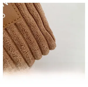 Detailed close-up of brown corduroy fabric texture with a premium leather brand tag