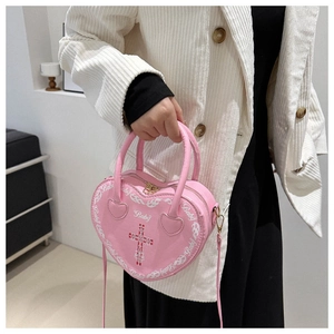 Detail of pink heart-shaped bag with white flame print and Baby text in Y2K style