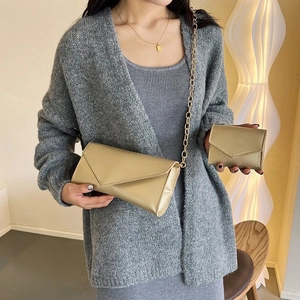 Detail of champagne gold envelope crossbody bag with fine chain and matching small wallet