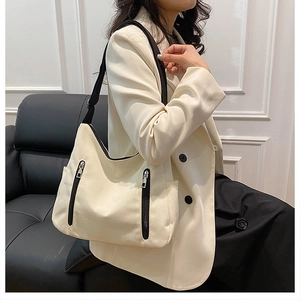 Détail d'un sac cabas en toile blanc cassé avec doubles fermetures éclair verticales