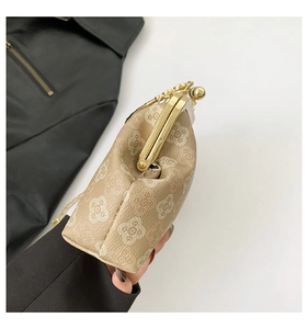 Dettaglio della mini borsa in pelle kaki con motivi a quadrifoglio e chiusura in metallo