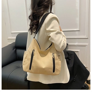Détail du sac cabas kaki avec doubles fermetures éclair dorées et bandoulière noire