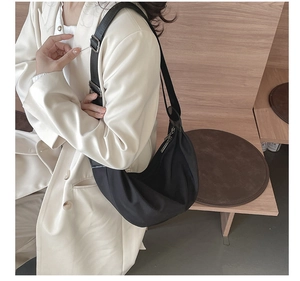 Detail of black nylon hobo bag featuring wide adjustable strap and silver metal buckle