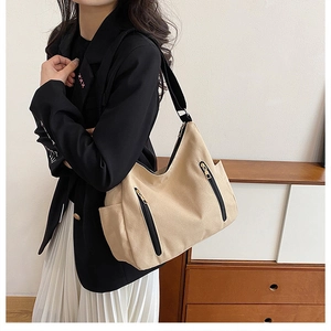Vue détaillée du sac cabas en toile kaki avec bretelles noires porté par un modèle
