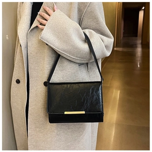 Detail showing the pleated black PU leather texture and gold buckle on a crossbody bag