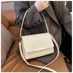 Detail of off-white pleated leather crossbody bag with minimalist gold metal trim