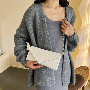 Chic white envelope clutch with gold chain strap styled with a grey cardigan