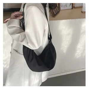 Detail of black crescent hobo bag featuring wide adjustable strap and nylon texture