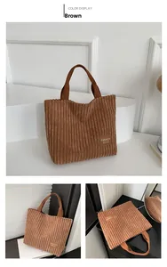 Close-up of brown corduroy tote bag showing ribbed texture and fashion logo label