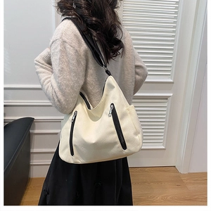 Détail du grand sac cabas en toile montrant les fermetures éclair et la bandoulière