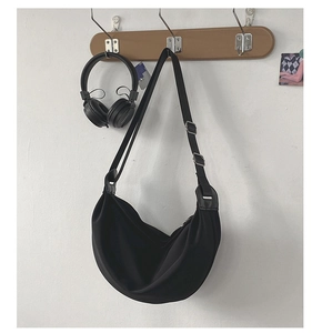 Detail of black crescent moon bag with adjustable shoulder strap and metallic buckle
