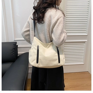 Vue détaillée du grand sac cabas en toile blanc cassé porté par un mannequin en intérieur