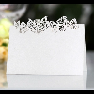 Elegant white laser-cut butterfly place cards made of textured paper for weddings